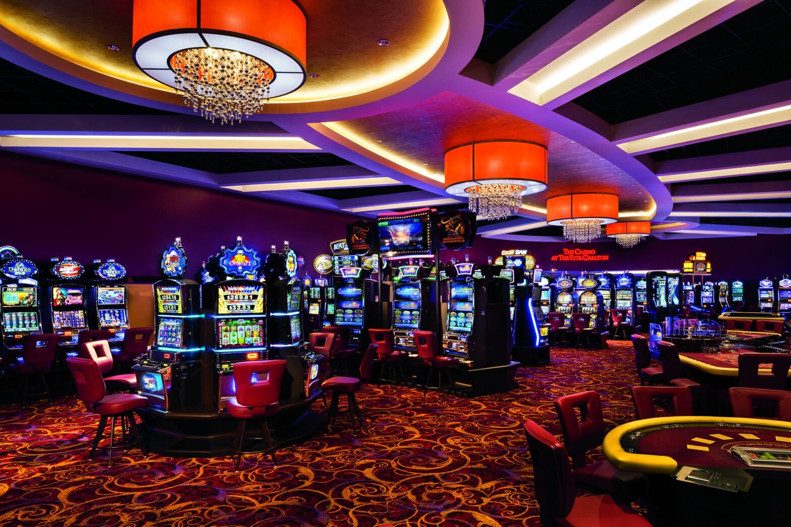 Casino interior with slot machines and chandeliers.