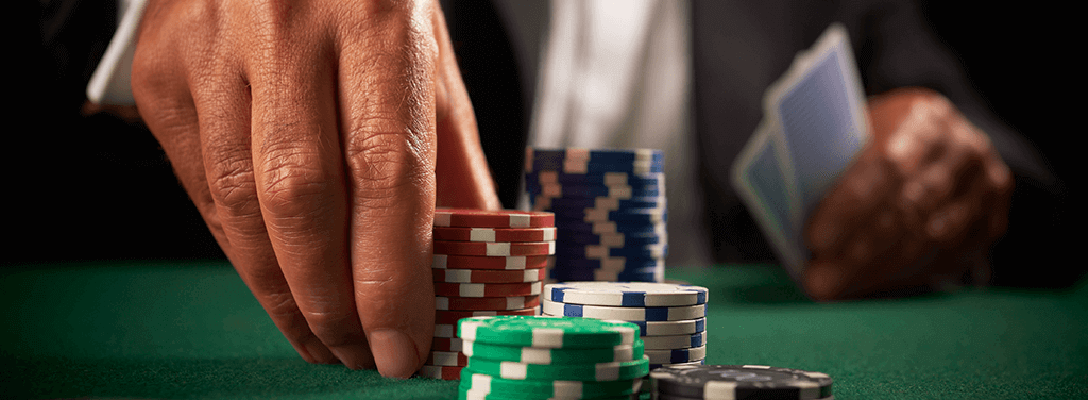Poker chips and cards on green table.