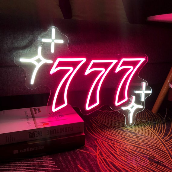 Neon sign displaying number 777 with stars.